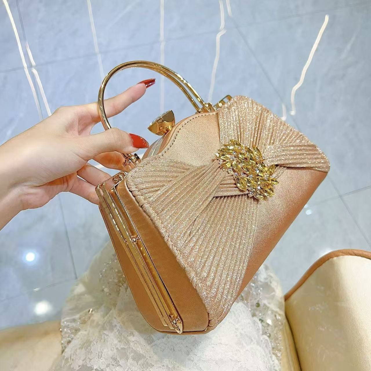 Gold crystal handbag shown by hand